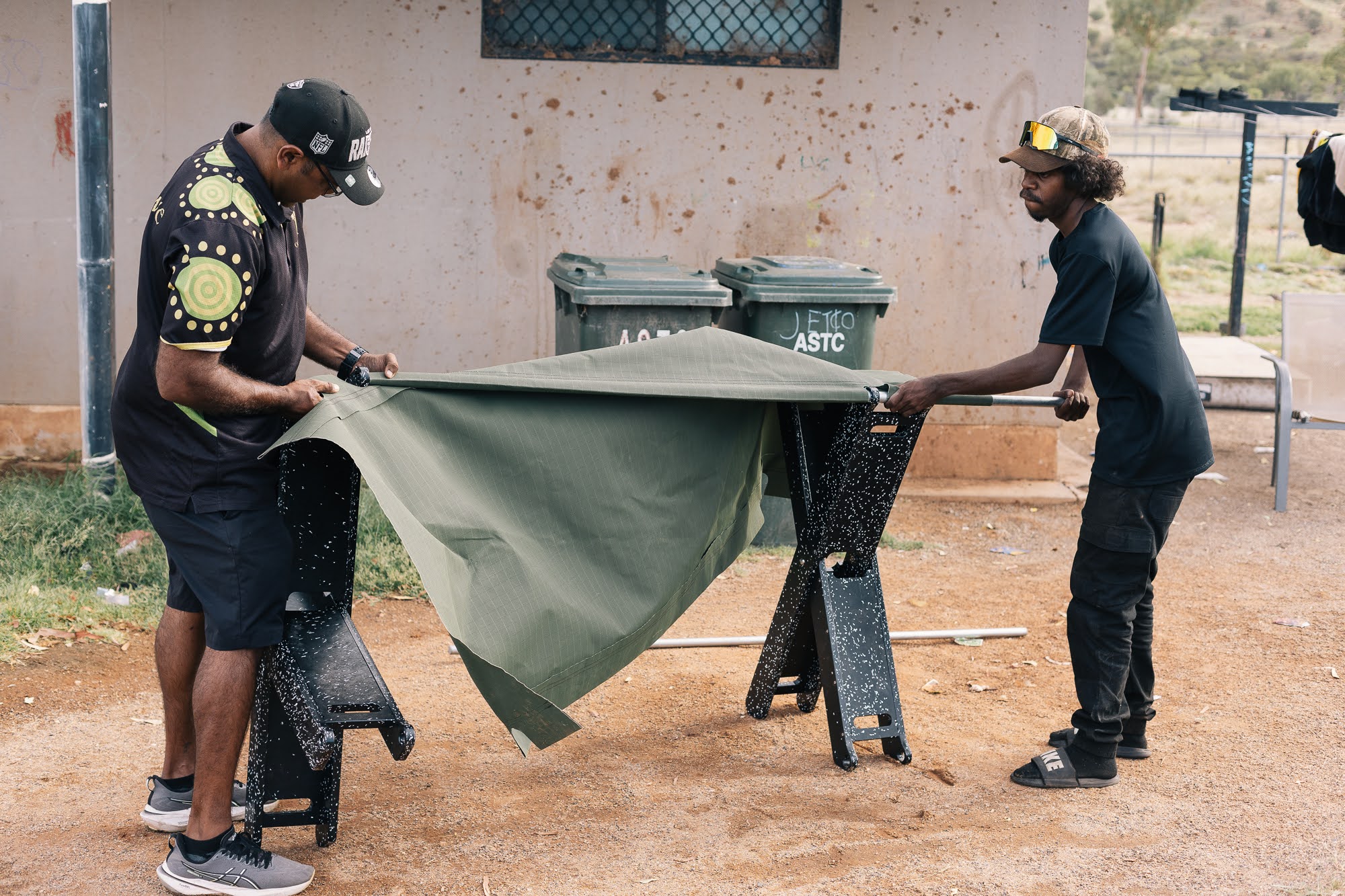 Two young men assembling a Stretch Bed on Country